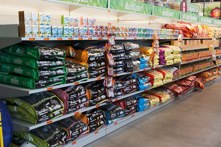Hyllor i butiken fyllda med olika hundfoderprodukter.
