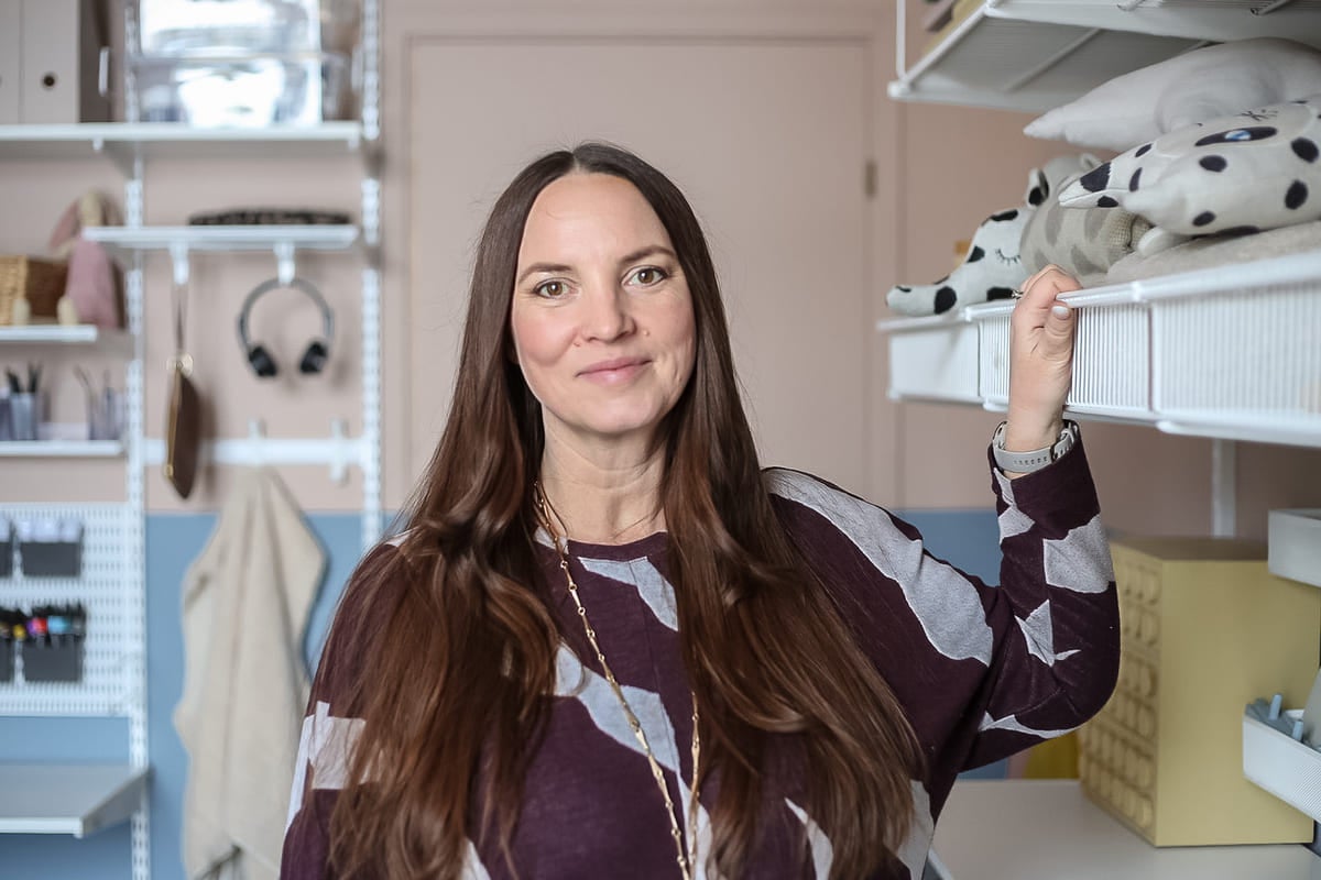 Kvinna framför ett hyllsystem med förvaringslådor