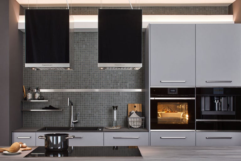 Modernt kök med fläkt, diskho, spishäll och inbyggda apparater