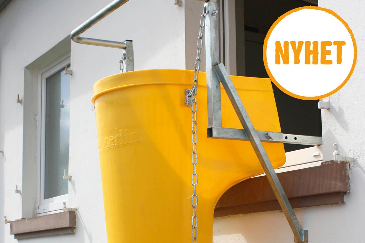 Nedkast för byggavfall med tratt och fönsterfäste i metall på en fasad. Symbol för nyhet.