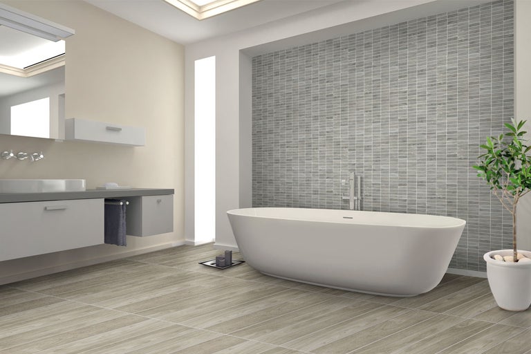 Modernt badrum med badkar, handfat och grått kakel