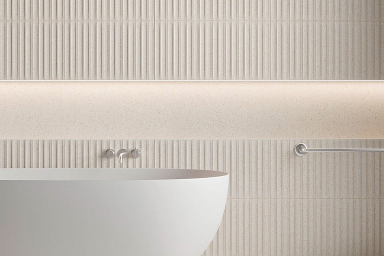Badrum med badkar, armaturer och kakel i räfflad design
