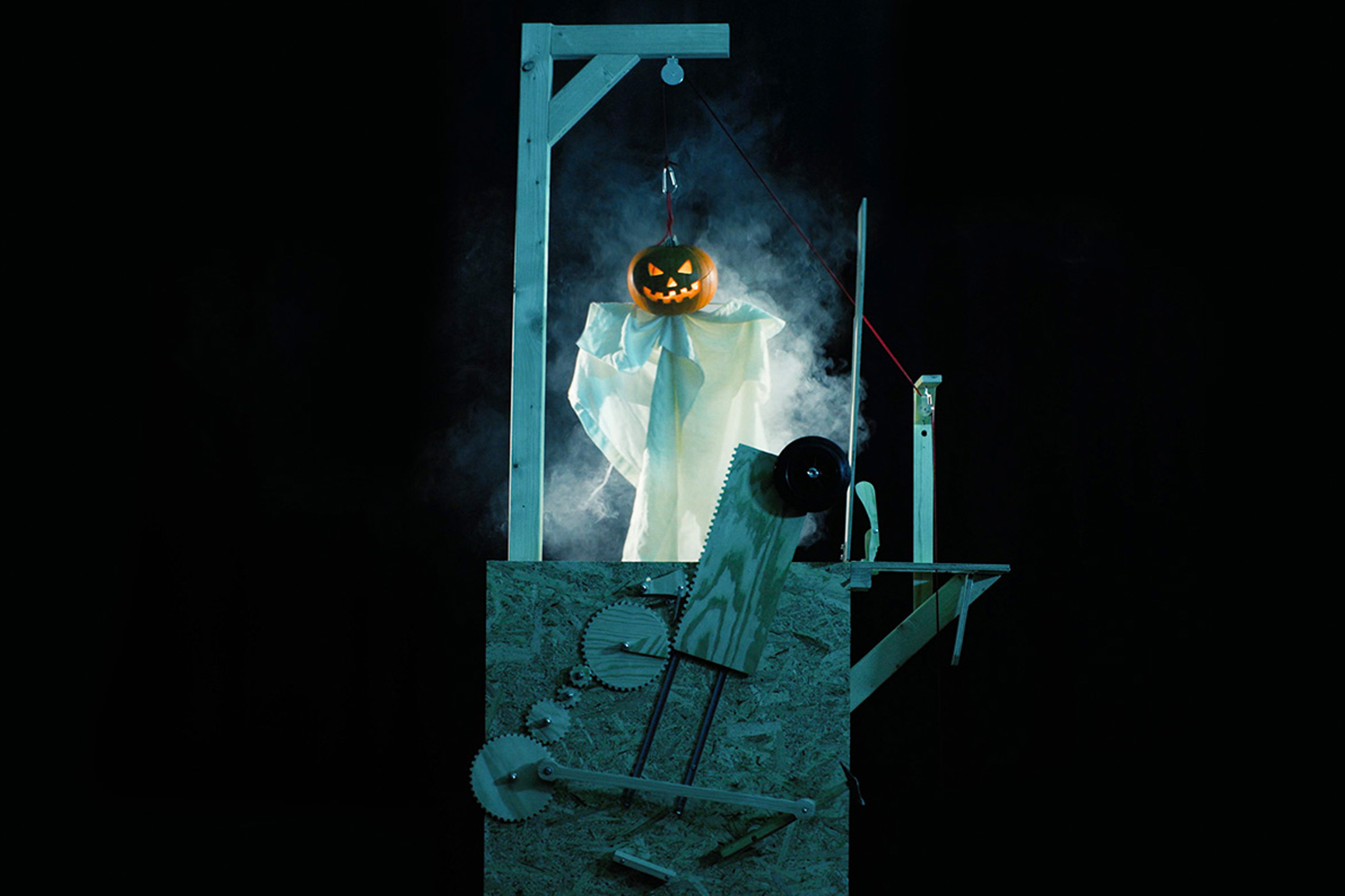 Halloweendekoration med pumpaspöke och träkonstruktion