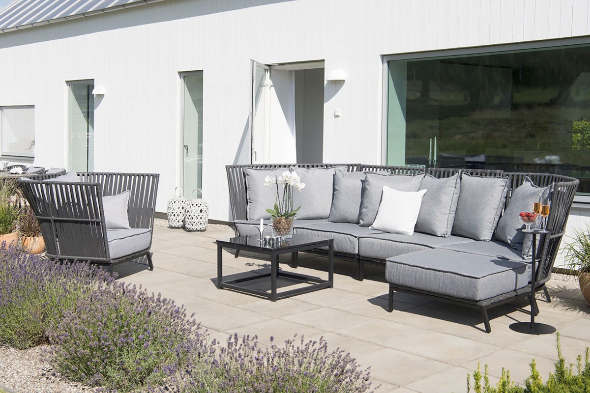 Uteplats med soffa, fåtölj och bord på en terrass