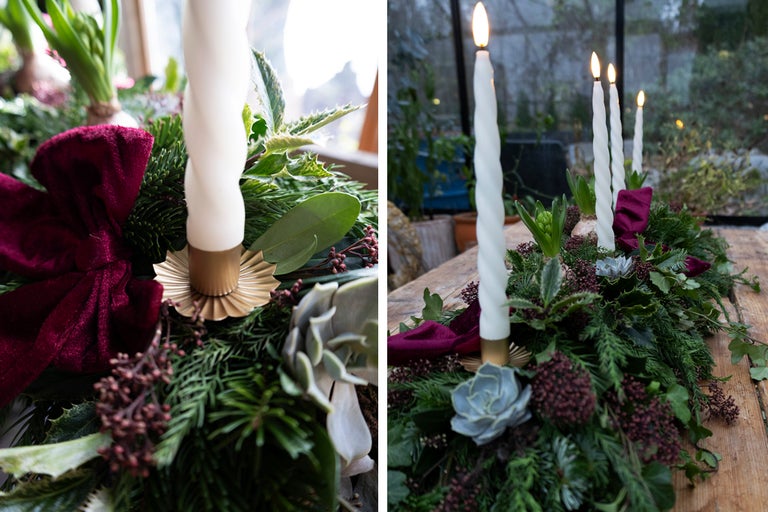 Dekoration med ljus, rosett och grönt på ett bord