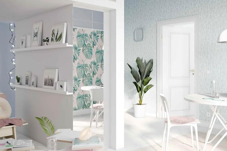 Ljust rum med hyllor, dekoration, tapet med växtmönster och bordsgrupp.