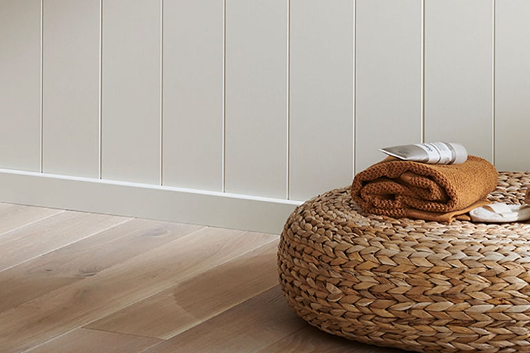 Väggpanel med matchande golvsockel, rottingpall med handduk och tub