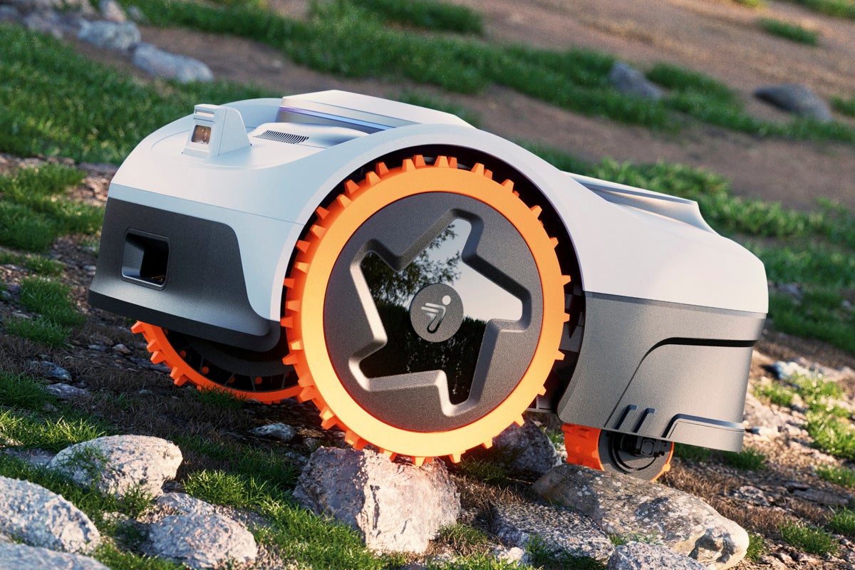 Robotgräsklippare på ojämn terräng med stenar och gräs