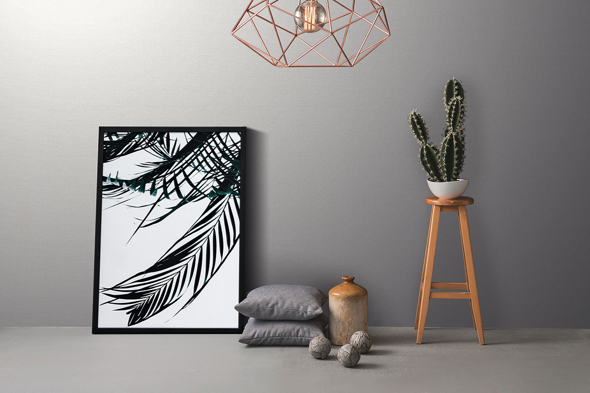 Dekorativt rum med fotoram, växt, lampa och tillbehör