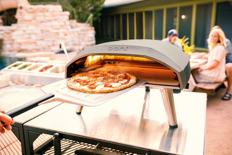 Ooni pizzaugn med pizza på pizzaspade utomhus