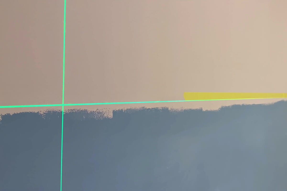 Vägg med färgskikt, markering med laseranordning och tejp