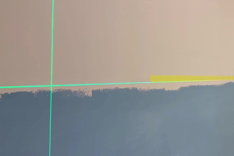 Vägg med färgskikt, markering med laseranordning och tejp