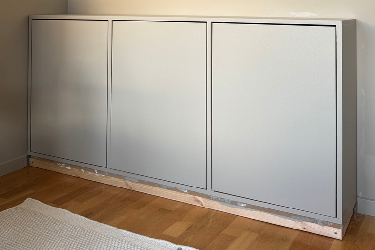 Vägghylla med tre dörrar på träbjälkar