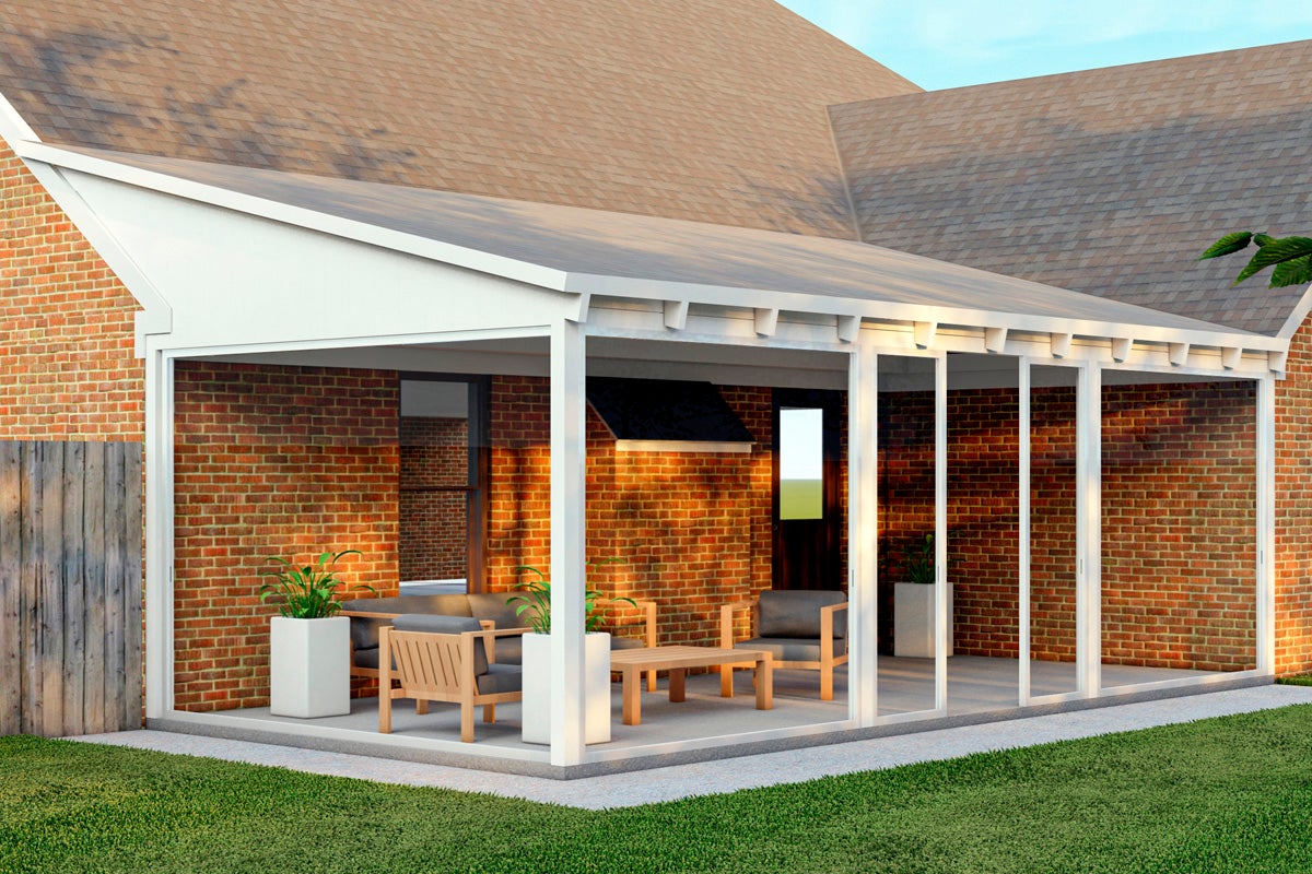 Övertäckt uteplats med trädgårdsmöbler och blomlådor vid ett tegelhus.