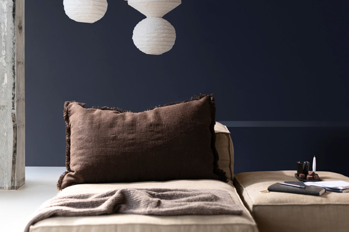 Dekorativt vardagsrum med kudde, filt och papperslyktor