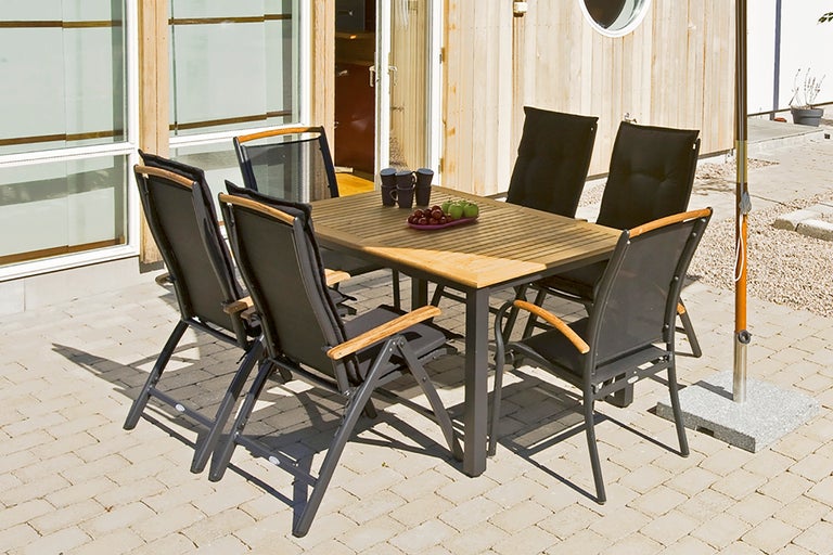 Uteplats med matbord och sex stolar på en terrass.