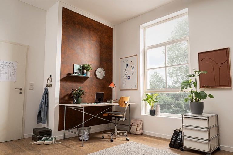 Ljust arbetsrum med skrivbord, stol, vägghylla, krukväxter och dekorativ väggdesign