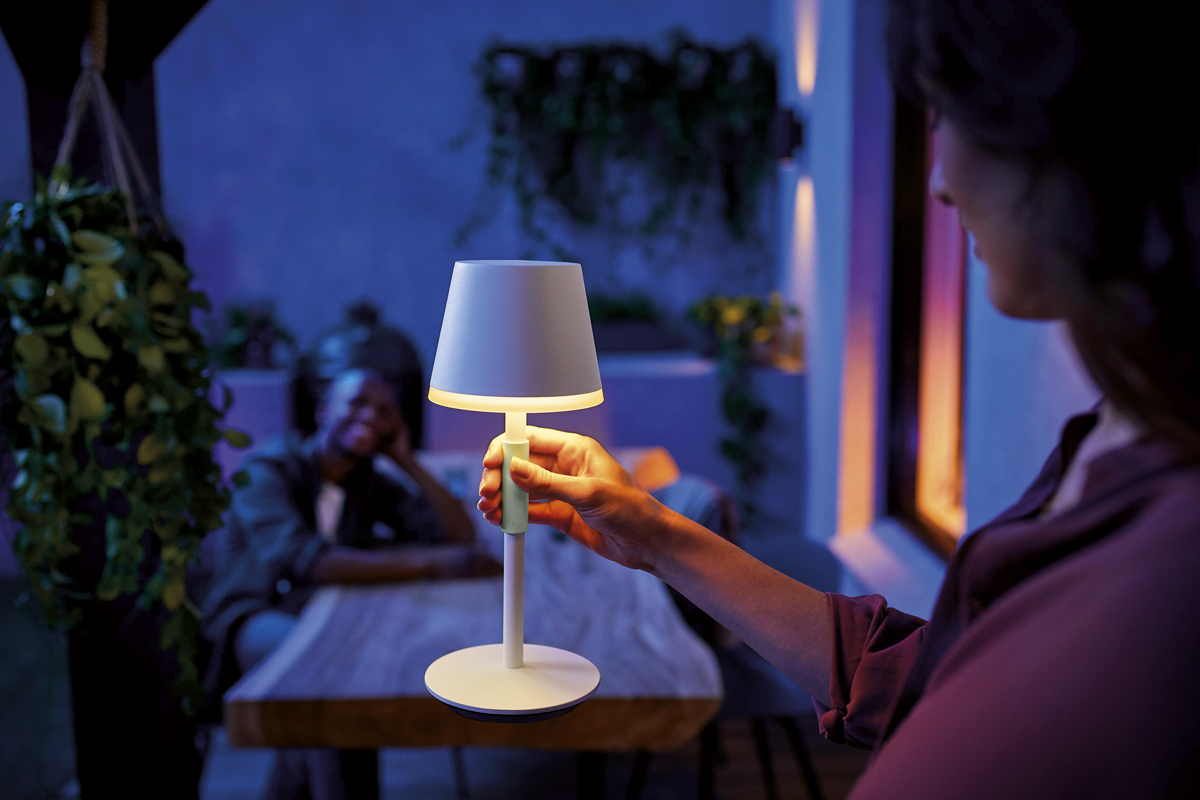 Scen med en person som använder en bordslampa utomhus för stämningsbelysning