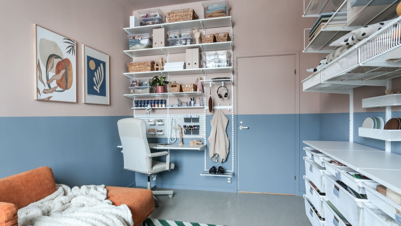 Ljust arbetsrum med hyllsystem, skrivbord och kontorsstol