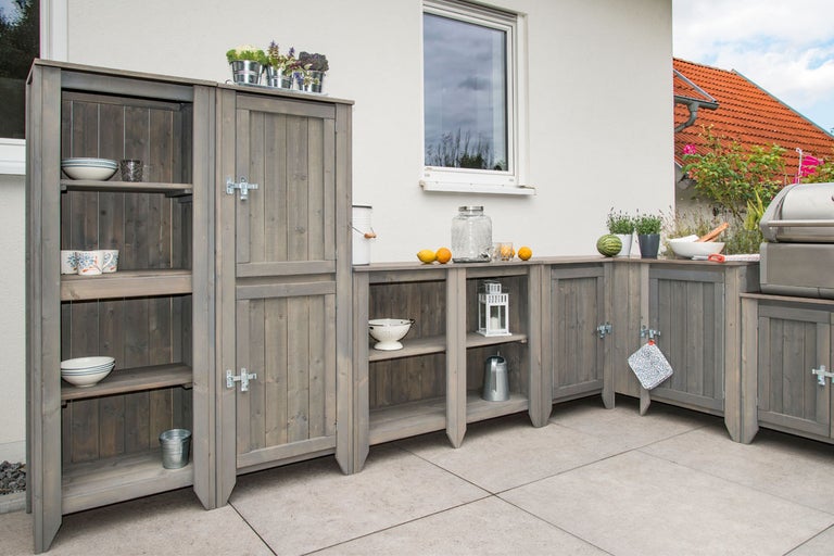 Utekök i trä med skåp, hyllor och arbetsytor på en terrass