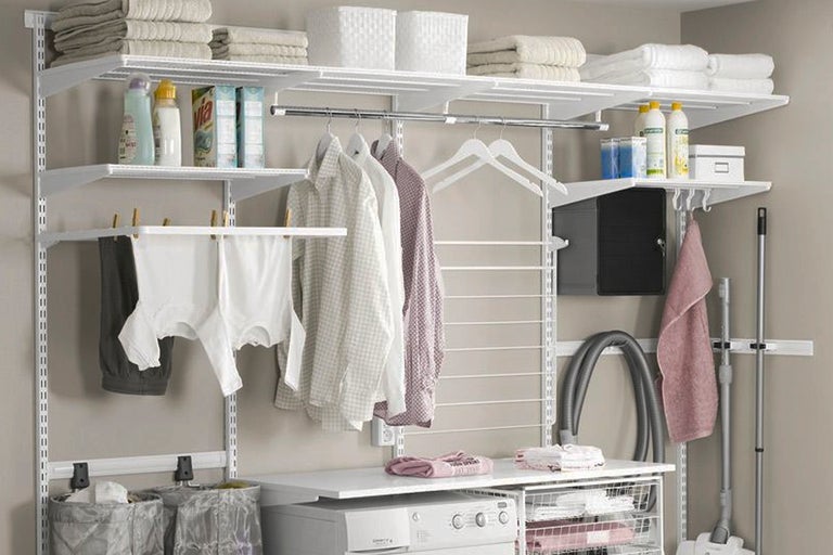 Exempel på ett klädskåpssystem med hyllor, klädstänger, torkställningar, tvättkorgar och en tvättmaskin i en tvättstuga.