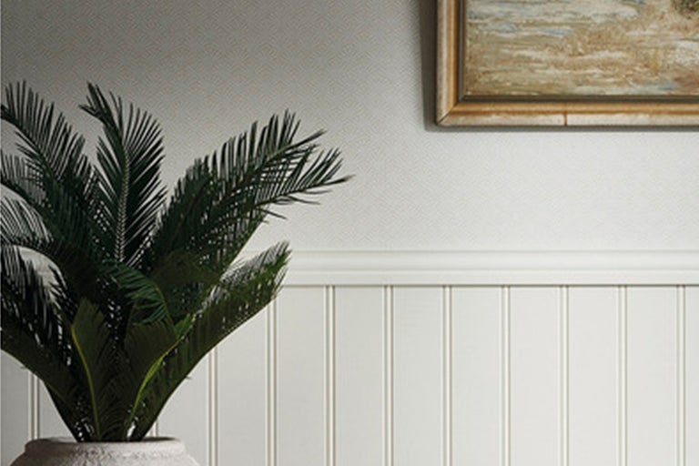 Väggdekoration med träpanel, kant, mönstrad tapet och en inramad bild