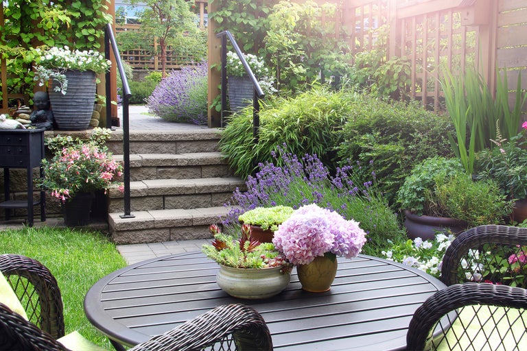 Trädgård med bord, stolar, blommor och trappor