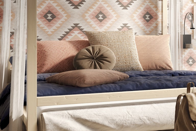 Säng med olika kuddar och mönstrad bakgrund