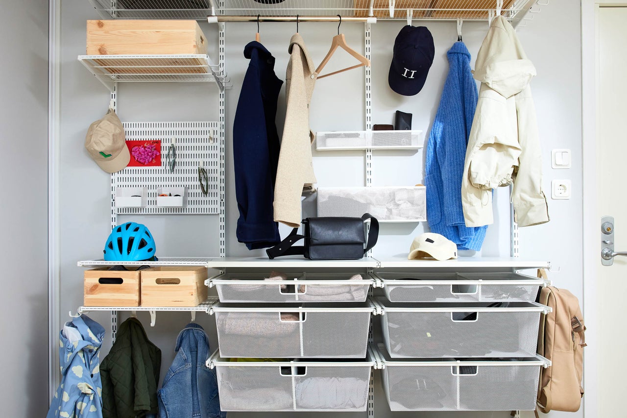 Organiserat skåpsystem med hyllor, klädstänger och förvaringskorgar för kläder och accessoarer