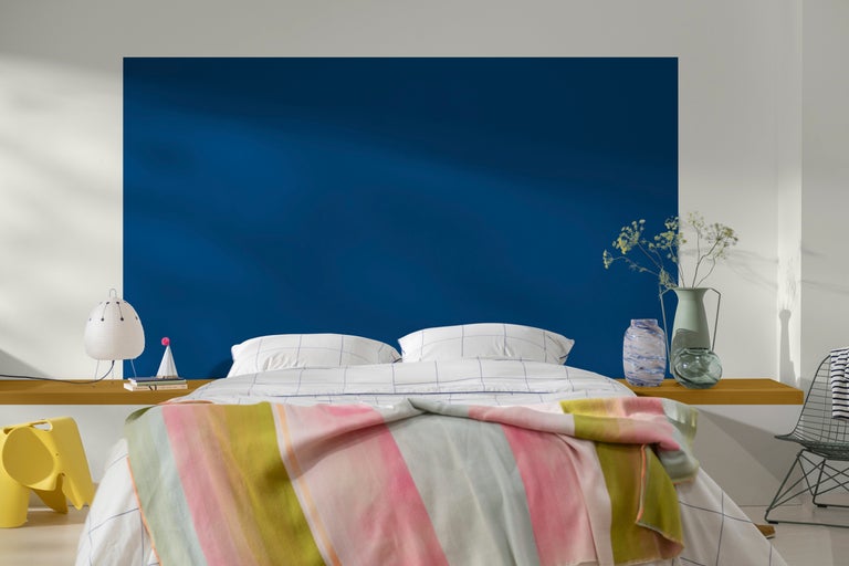 Sovrum med säng, sänglampa och dekorativa vaser för en lugn atmosfär