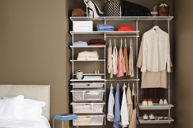 Öppen garderob med hyllor, klädstänger och förvaringskorgar för att organisera kläder och accessoarer.