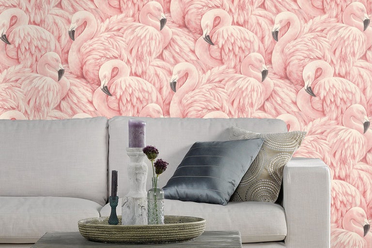 Vardagsrum med soffa framför en tapet med flamingor