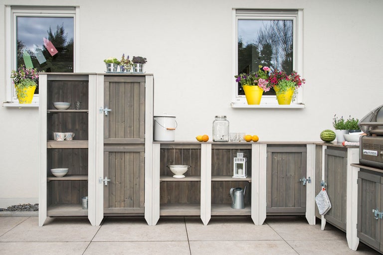 Utekök av trä med skåp, hyllor och arbetsyta i trädgården