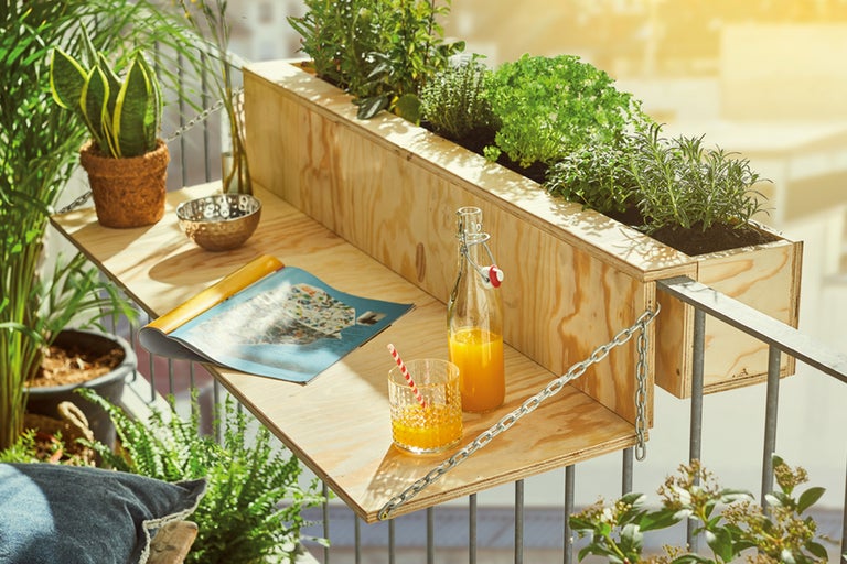 Balkongscen med träbord, örter och drycker för en avslappnad atmosfär
