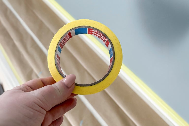 En hand håller en rulle maskeringstejp