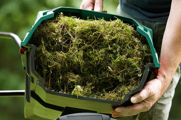 Grasuppsamlare till en trädgårdsfräs fylld med gräsklipp