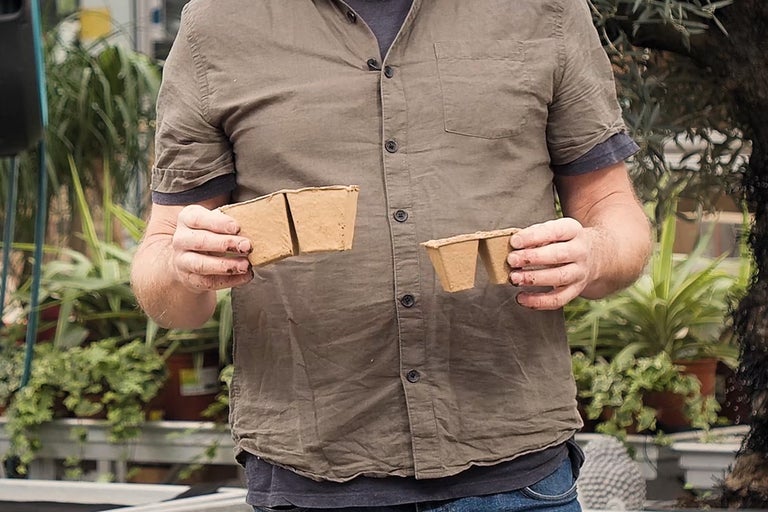 En person håller två planteringsbrickor