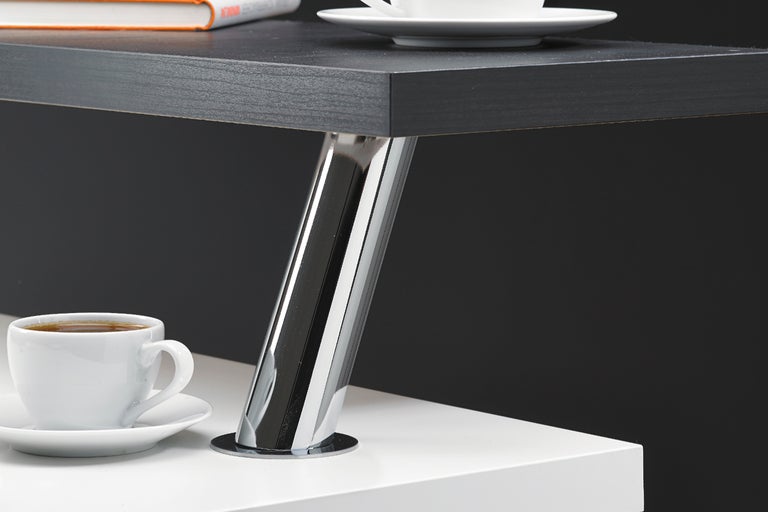 Detaljvy av en hylla med bordsben i metall och en kopp kaffe