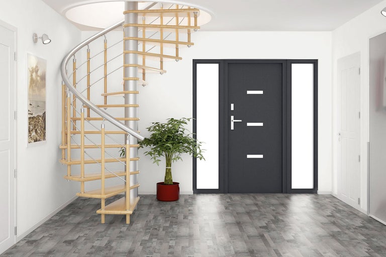 Miljöbild med spiraltrappa, ytterdörr och krukväxt i en ljus hall