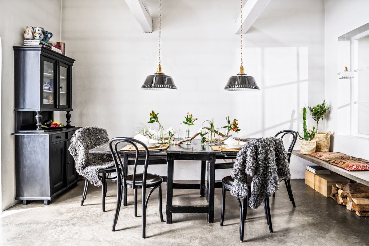 Matsal med matbord, stolar, hänglampor och skänk