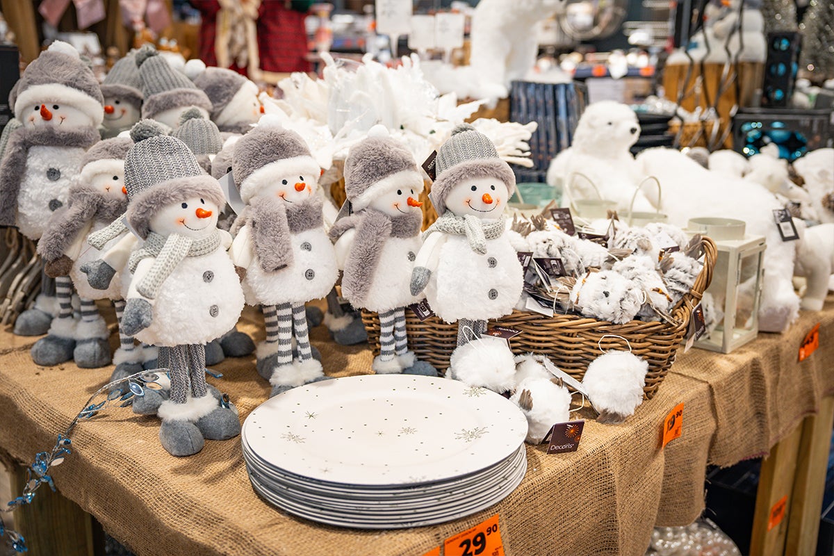 Dekorationsartiklar med snögubbmotiv och tallrikar på ett bord