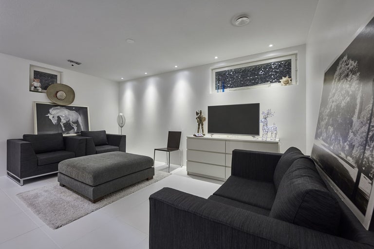 Vardagsrum med soffa, fåtöljer, ottoman, byrå och TV