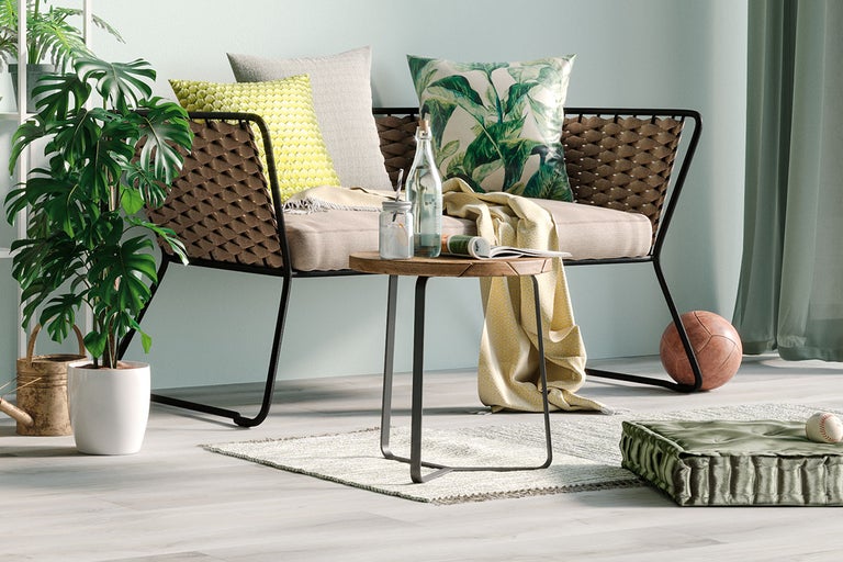 Dekorativ interiör med rottingsoffa, kuddar, träbord och krukväxt för inredning