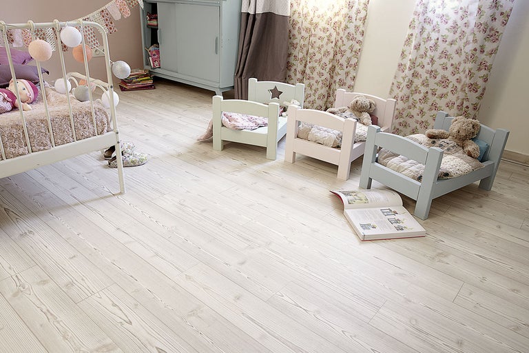Barnrum med trägolv, leksaksängar och dekorationer för en mysig atmosfär.