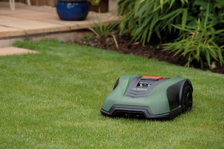 Robotgräsklippare på en gräsmatta i trädgården