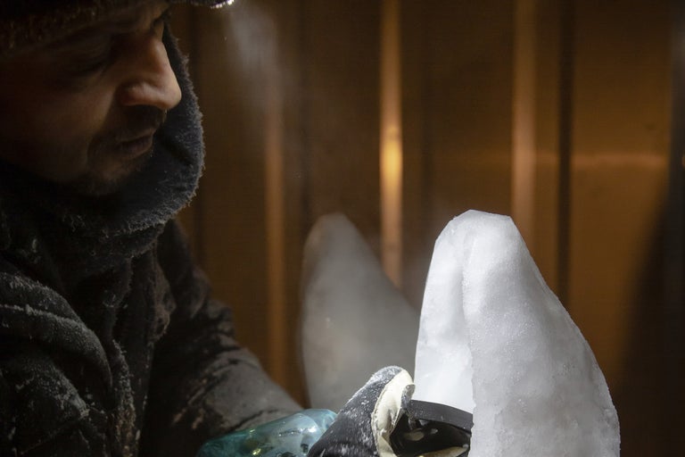 Man mejslar isblock med verktyg.