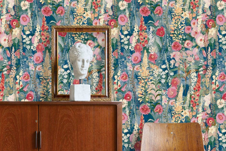 Dekorativ interiör med blomstertapet och konstföremål på ett träskåp.