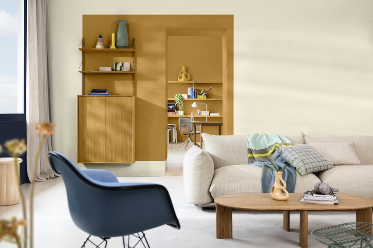 Ljust vardagsrum med soffa, bord, stol och hyllsystem