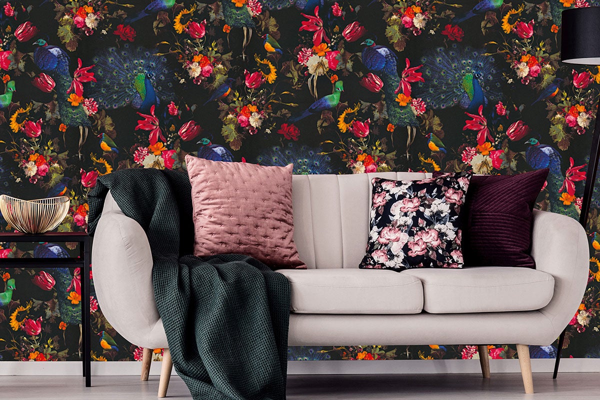 Rumsdekoration med soffa, kuddar och tapet med iögonfallande mönster med blom- och fågelmotiv