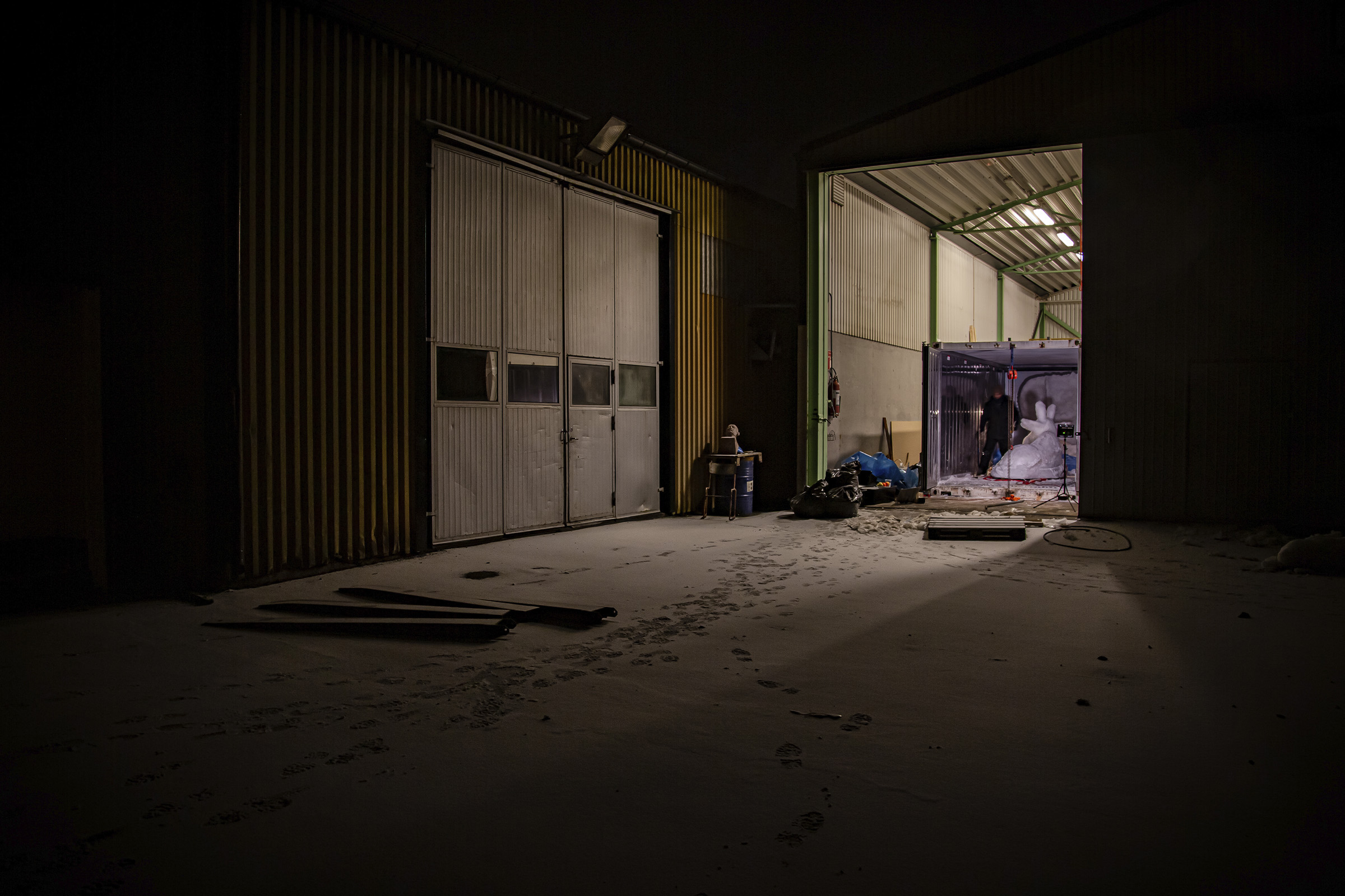 Mörk lagerlokal med rullport och öppen container